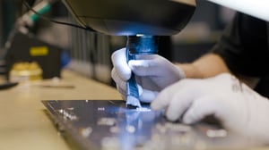 Person working on a PCB board