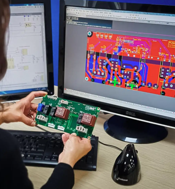 En person som håller i ett elektroniskt kretskort (PCB)